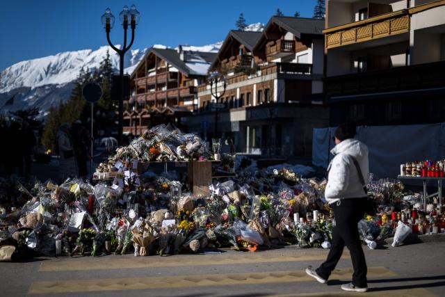 This photograoh shows flowers, candles and messages at a makeshift memorial near the Constellation bar for the victims of the fire that ripped through the venue on New Year's Eve in the luxury Alpine ski resort of Crans-Montana on January 6, 2026. (Photo by Fabrice COFFRINI / AFP)
