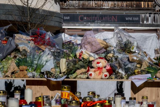 This photograoh shows flowers, candles and messages at a makeshift memorial near the Constellation bar for the victims of the fire that ripped through the venue on New Year's Eve in the luxury Alpine ski resort of Crans-Montana on January 6, 2026. (Photo by Fabrice COFFRINI / AFP)