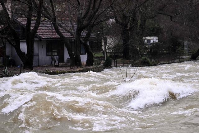 A threatened house is seen on the bank, near the spring of river Buna, following heavy rain in southern-Bosnian town of Blagaj on January 6, 2026. Snow and heavy rains sparked power failures and flooding in parts of the Balkans, authorities said on January 6, 2026, with one woman dead in a weather-related accident in Bosnia. (Photo by ELVIS BARUKCIC / AFP)