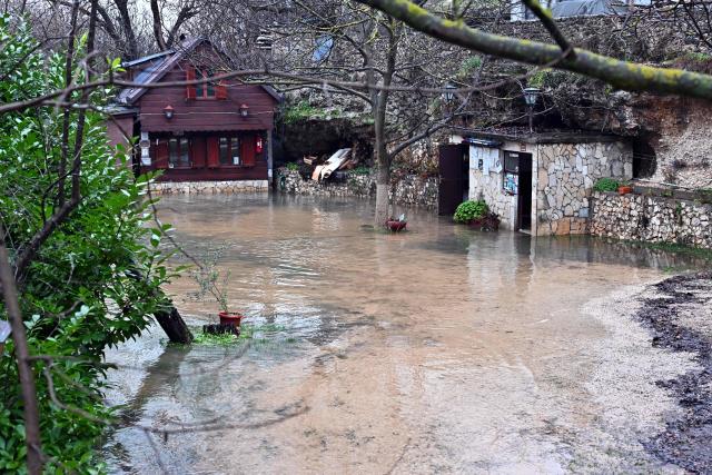 This photograph shows a flooded yard following heavy rain in southern-Bosnian town of Blagaj on January 6, 2026. Snow and heavy rains sparked power failures and flooding in parts of the Balkans, authorities said on January 6, 2026, with one woman dead in a weather-related accident in Bosnia. (Photo by ELVIS BARUKCIC / AFP)