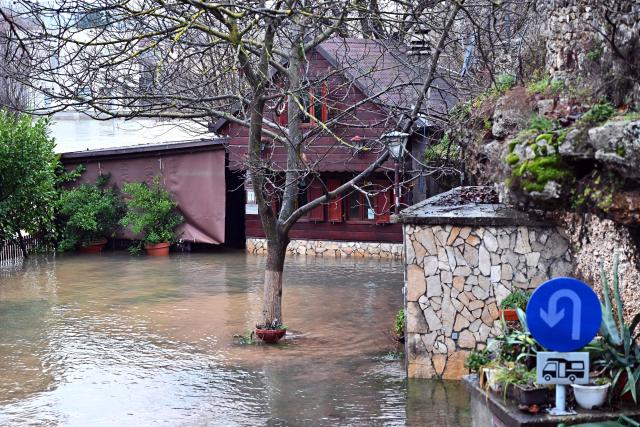 This photograph shows a flooded yard following heavy rain in southern-Bosnian town of Blagaj on January 6, 2026. Snow and heavy rains sparked power failures and flooding in parts of the Balkans, authorities said on January 6, 2026, with one woman dead in a weather-related accident in Bosnia. (Photo by ELVIS BARUKCIC / AFP)