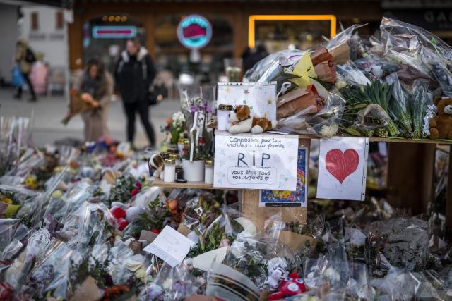 This photograph shows flowers, candles and messages at a makeshift memorial near the Constellation bar for the victims of the fire that ripped through the venue on New Year's Eve in the Alpine ski resort of Crans-Montana on January 6, 2026. (Photo by Fabrice COFFRINI / AFP)