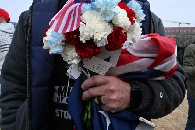 A man holds flowers as he attends a rally promoted by right-wing activists on the fifth anniversary of the January 6 riots in Washington, DC, on January 6, 2026. Washington on Tuesday marks five years since a mob overran the US Capitol, with rioters pardoned by Donald Trump retracing their steps even as Democrats revive hearings to hold the president accountable. The anniversary highlights a nation divided between irreconcilable accounts of an attack that reshaped American politics -- one supported by official findings of a violent bid to overturn an election, the other portraying it as a protest unjustly criminalized. (Photo by ROBERTO SCHMIDT / AFP)