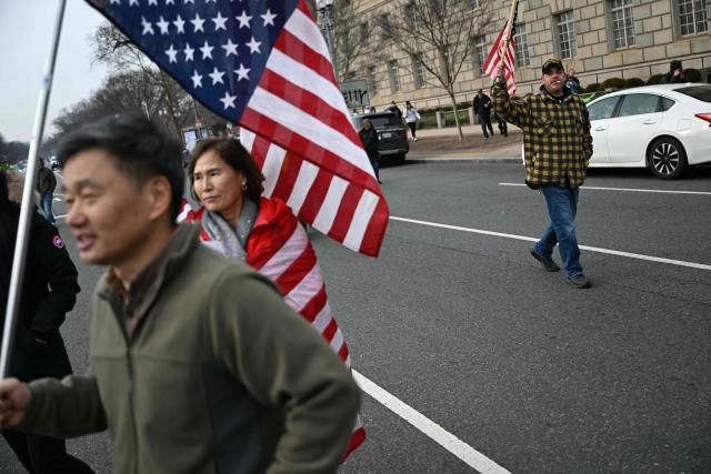 People attend a rally promoted by right-wing activists on the fifth anniversary of the January 6 riots in Washington, DC, on January 6, 2026. Washington on Tuesday marks five years since a mob overran the US Capitol, with rioters pardoned by Donald Trump retracing their steps even as Democrats revive hearings to hold the president accountable. The anniversary highlights a nation divided between irreconcilable accounts of an attack that reshaped American politics -- one supported by official findings of a violent bid to overturn an election, the other portraying it as a protest unjustly criminalized. (Photo by Brendan SMIALOWSKI / AFP)