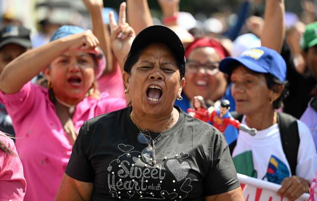 A woman shouts slogans during a rally in support of ousted Venezuela's President Nicolas Maduro and his wife Cilia Flores in Caracas on January 6, 2026. US forces killed 55 Venezuelan and Cuban military personnel during their stunning raid to capture Nicolas Maduro, tolls published by Caracas and Havana showed on January 6. (Photo by RONALDO SCHEMIDT / AFP)