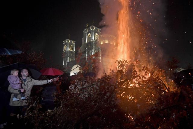Montenegrin Orthodox Christians, throw oak branches on a bonfire after Christmas Eve mass, at the Church of "The Resurection of Jesus Christ", in Podgorica on January 6, 2026. Orthodox Christian believers in Montenegro, observe Christmas in accordance with old "Julian" calendar. (Photo by SAVO PRELEVIC / AFP)