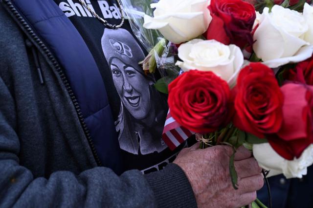 A person holds a bouquet of flowers for Killed January 6 rioterAshli Babbitt as people march to the US Capitol in a rally promoted by right-wing activists on the fifth anniversary of the January 6 riots in Washington, DC, on January 6, 2026. (Photo by ROBERTO SCHMIDT / AFP)