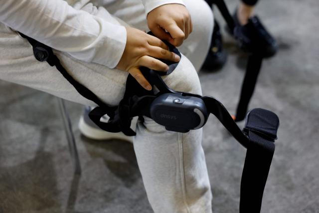 A person puts on the dnsys X1 hip exoskeleton at the annual Consumer Electronics Show (CES) in Las Vegas, Nevada, on January 6, 2026. (Photo by Caroline Brehman / AFP)