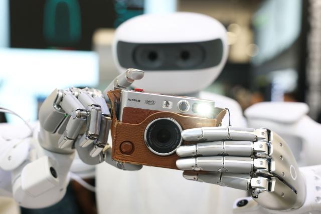 The Sharpa robot takes a photograph with a Fujifilm instax camera during the annual Consumer Electronics Show (CES) in Las Vegas, Nevada on January 6, 2026. (Photo by Patrick T. Fallon / AFP)
