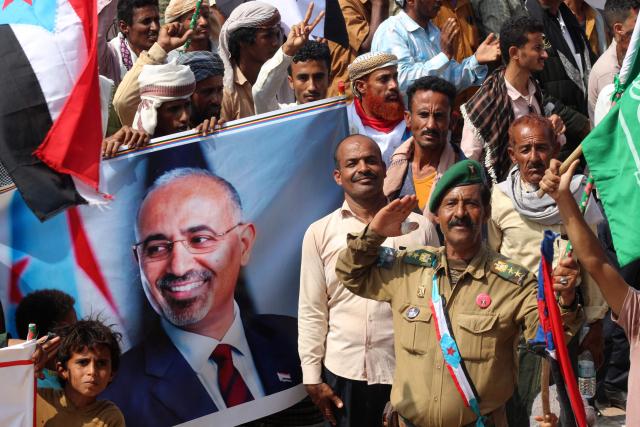 (FILES) Yemenis members of the Sabahiha tribes of Lahj, who live along the strip between the south and north of the country and who support the UAE-backed Southern Transitional Council (STC), hold an image of the STC leader Aidaros Alzubidi as they wave the old South Yemen flag, during a rally in  Khormaksar Square, in the coastal port city of Aden, the temporary capital of the Republic of Yemen on December 14, 2025. More than 15 Saudi air strikes hit the home province of Yemen's separatist leader Aidaros Alzubidi on January 7, 2026 after he did not appear in Riyadh for peace talks, a Yemeni local official said. (Photo by Saleh Al-OBEIDI / AFP)
