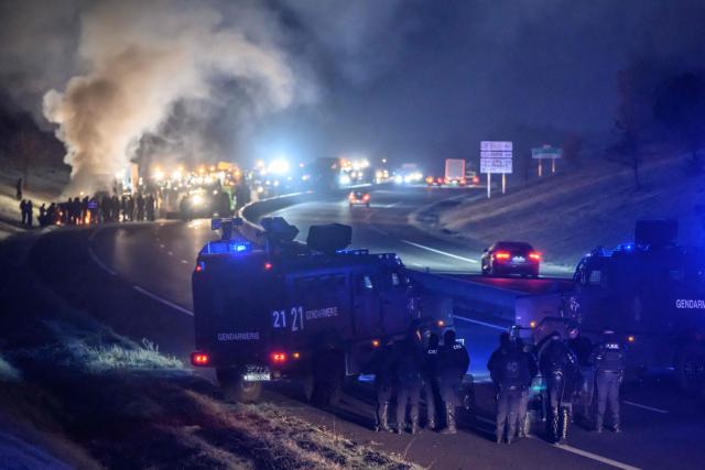 French gendarmes block a convoy of farmers from entering Toulouse as part of their protest to defend their profession and denounce the government's handling of the agricultural crisis, near Leguevin on January 7, 2026. Several farmers' unions called for people reach Toulouse, which they plan to "paralyze" or disrupt but the prefect has issued several prohibition orders in response to these mobilisation plans. (Photo by Ed JONES / AFP)