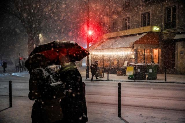 Pedestrians walk in the streets during heavy snow falls, in Paris, on January 7, 2026. All buses in Paris and the surrounding region gradually stopped running at around 7am due to renewed snowfall in the area and returned to their depots, according to announcements by Ile-de-France Mobilitйs (IDFM) and RATP. Snow and ice are affecting northern and western France, a phenomenon of “rare magnitude in the current climate” according to Meteo-France, which is expected to cause significant restrictions on roads and air transport. (Photo by Christophe DELATTRE / AFP)
