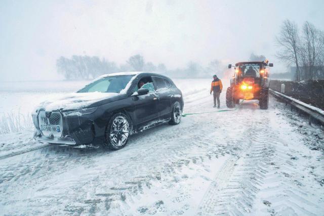 CORRECTION / A local town hall employee attempts to tow a stranded vehicle on a snow-covered road near Sebourg, northern France, on January 7, 2026. (Photo by Francois LO PRESTI / AFP) / “The erroneous mention[s] appearing in the metadata of this photo by Francois LO PRESTI has been modified in AFP systems in the following manner: [2026] instead of [2025]. Please immediately remove the erroneous mention[s] from all your online services and delete it (them) from your servers. If you have been authorized by AFP to distribute it (them) to third parties, please ensure that the same actions are carried out by them. Failure to promptly comply with these instructions will entail liability on your part for any continued or post notification usage. Therefore we thank you very much for all your attention and prompt action. We are sorry for the inconvenience this notification may cause and remain at your disposal for any further information you may require.”