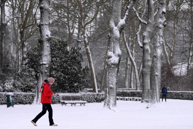 Pedestrians walk in a public park covered in snow in Brussels, on January 7, 2026. (Photo by Nicolas TUCAT / AFP)