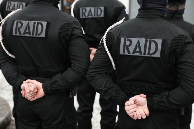 Members of French National Police elite unit RAID (Research, Assistance, Intervention, Deterrence) pay their respects in front of Hypercacher supermarket in Paris on January 7, 2026, during commemorations marking 11 years since an Islamist attack on the Charlie Hebdo satirical newspaper and the Hypercacher Jewish supermarket. Twelve people died in the attacks, including eight editorial staff, while a separate but linked hostage-taking at a Jewish supermarket in eastern Paris by a third gunman on January 9, 2015, claimed another four lives. The bloodshed signalled the start of a dark period for France during which extremists inspired by Al-Qaeda and the Islamic State group repeatedly mounted attacks that set the country on edge and raised religious tensions. (Photo by Thomas SAMSON / AFP)