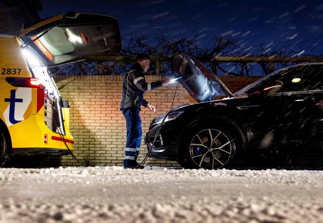 An ANWB roadside assistance worker attends to a breakdown during heavy snowfall in Assendelft on January 7, 2026. (Photo by Koen van Weel / ANP / AFP) / Netherlands OUT