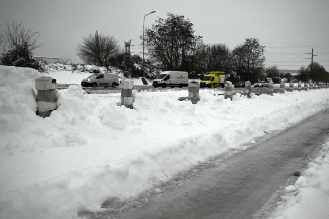 This photograph shows piles of snow and ice covering the entrance to the toll plaza as vehicles queue on the A10 motorway near Saintes, western France, on January 7, 2026, following snowfalls. (Photo by Philippe LOPEZ / AFP)