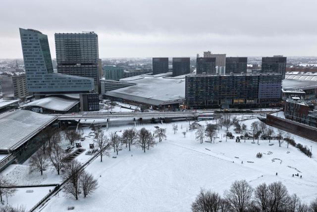An aerial view shows the Lille Europe railway station and the Lille Tower (L) in downton Lille, northen France, following a fresh snowfall on January 7, 2026. (Photo by Anthony Brzeski / AFP)