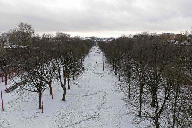 An aerial view shows a park in downton Lille, northen France, following a fresh snowfall on January 7, 2026. (Photo by Anthony Brzeski / AFP)