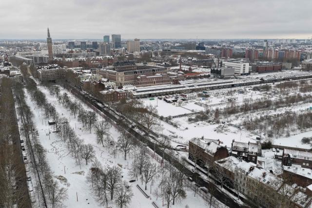 An aerial view shows a park and the former Saint Sauveur railway station, turned Cultural and Event Center (R) in downton Lille, northen France, following a fresh snowfall on January 7, 2026. (Photo by Anthony Brzeski / AFP)