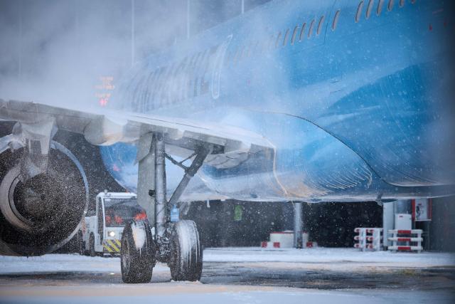 This photograph shows an airplane with its wheels frozen after heavy snowfalls which caused flight cancellations at Orly Airport, south of Paris on January 7, 2026. Around 100 flights were cancelled at Paris's Charles de Gaulle airport because of snowfall and fierce cold, and a further 40 were cancelled at Orly airport, France's transport minister said. (Photo by Kiran RIDLEY / AFP)