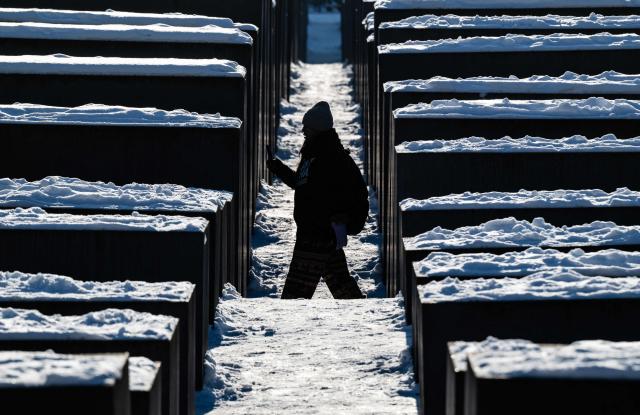 A visitor walks through the snow-covered steles of the Holocaust memorial in Berlin on January 7, 2026 following abundant snow fall and sub-zero temperatures in the capital. (Photo by John MACDOUGALL / AFP)