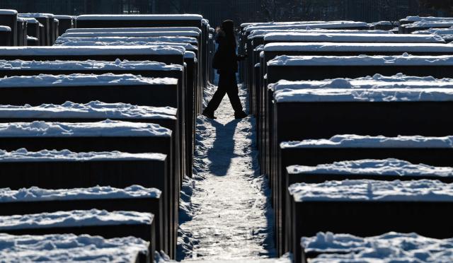 A visitor walks through the snow-covered steles of the Holocaust memorial in Berlin on January 7, 2026 following abundant snow fall and sub-zero temperatures in the capital. (Photo by John MACDOUGALL / AFP)