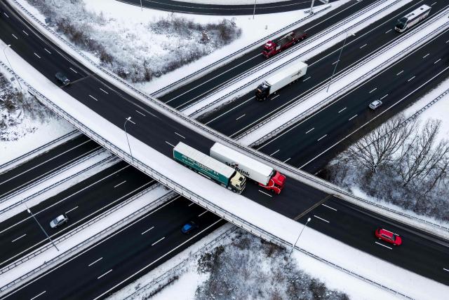 A picture taken near Utrecht on January 7, 2026 shows vehicles traveling on a highway in a snowy landscape at the Lunetten interchange. (Photo by Robin van Lonkhuijsen / ANP / AFP) / Netherlands OUT