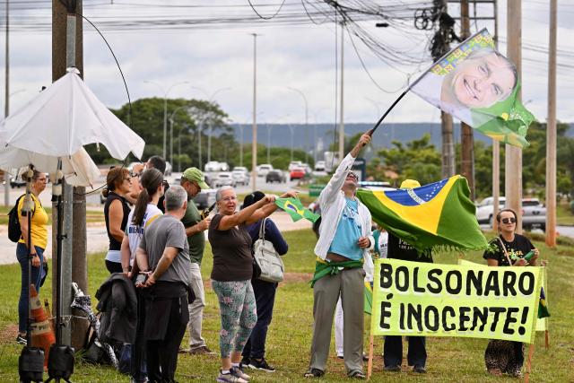 Supporters of former Brazilian President Jair Bolsonaro (2019-2022) protest against his arrest in front of the Federal Police headquarters in Brasilia on January 7, 2026. Bolsonaro was admitted to a hospital in Brasilia on January 7, after being transferred from prison, a day after he fell in his cell and hit his head, AFP journalists confirmed. (Photo by Evaristo Sa / AFP)