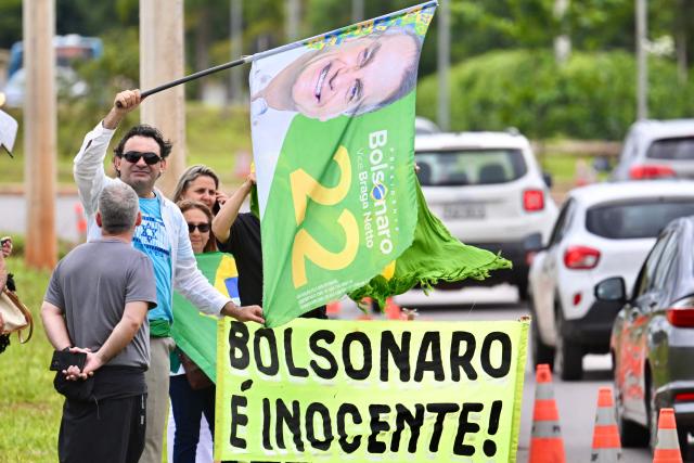 Supporters of former Brazilian President Jair Bolsonaro (2019-2022) protest against his arrest in front of the Federal Police headquarters in Brasilia on January 7, 2026. Bolsonaro was admitted to a hospital in Brasilia on January 7, after being transferred from prison, a day after he fell in his cell and hit his head, AFP journalists confirmed. (Photo by Evaristo Sa / AFP)