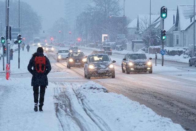 Traffic moves slowly through heavy snowfall in Aalborg, northern Denmark on January 7, 2026. Snow, ice and high winds brought transport chaos to swathes of Europe for a third day on January 7, 2026, with hundreds of flights cancelled and passengers stranded. (Photo by Henning Bagger / Ritzau Scanpix / AFP) / Denmark OUT