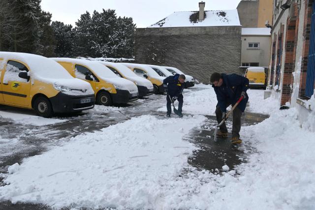 Postal workers clear snow from a parking lot in Illiers-Combray, central France, on January 7, 2026.  (Photo by JEAN-FRANCOIS MONIER / AFP)