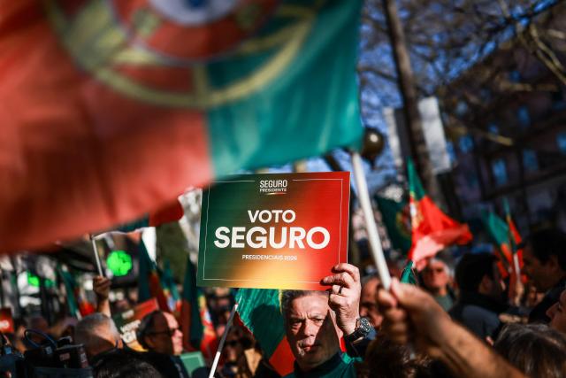 A supporter of Portuguese Socialist Party (PS) presidential candidate Antonio Jose Seguro holds up a placard reading "Vote Seguro" during a campaign rally for the Portuguese Presidential election in Lisbon on January 7, 2026. Portugal goes to the polls to elect a new president on January 18, 2026. (Photo by PATRICIA DE MELO MOREIRA / AFP)
