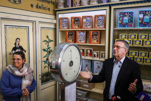 Portuguese Socialist Party (PS) presidential candidate Antonio Jose Seguro (R) gestures during a visit to a local shop during a rally as part of his campaign for the Portuguese Presidency in Lisbon on January 7, 2026. Portugal goes to the polls to elect a new president on January 18, 2026. (Photo by PATRICIA DE MELO MOREIRA / AFP)