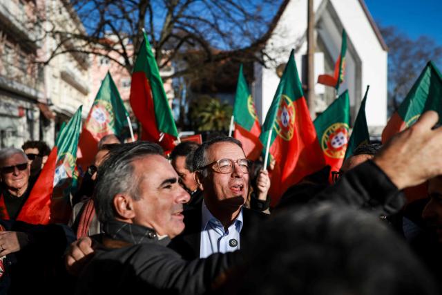 Portuguese Socialist Party (PS) presidential candidate Antonio Jose Seguro (C) takes a selfie with a supporter during a street rally as part of his campaign for the Portuguese Presidency in Lisbon on January 7, 2026. Portugal goes to the polls to elect a new president on January 18, 2026. (Photo by PATRICIA DE MELO MOREIRA / AFP)