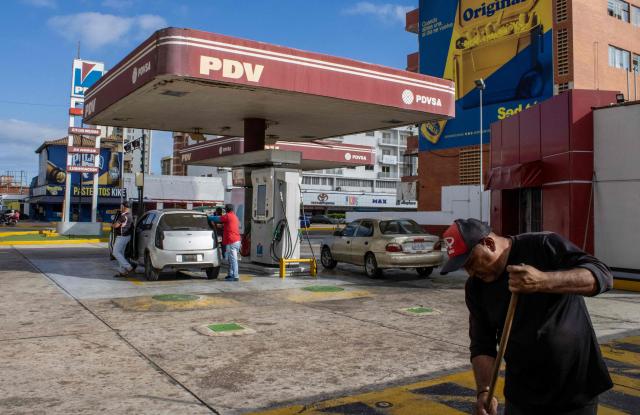 A worker sweeps around a gas station in Maracaibo, Venezuela, on January 7, 2026. US Energy Secretary Chris Wright said in January 7, Washington will control sales of Venezuelan oil "indefinitely," a day after President Donald Trump announced Venezuela's interim leaders had agreed to US-managed marketing of 30-50 million barrels of crude. (Photo by Margioni BERMÚDEZ / AFP)