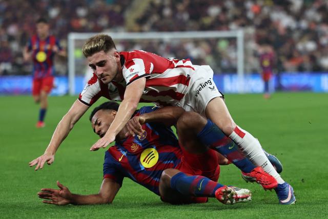 Barcelona's French defender #23 Jules Kounde and Athletic Bilbao's Spanish forward #23 Robert Navarro fall during the Spanish Supercup semi-final football match between FC Barcelona and Athletic Bilbao at King Abdullah Sports City in Jeddah on January 7, 2026. (Photo by Fadel SENNA / AFP)