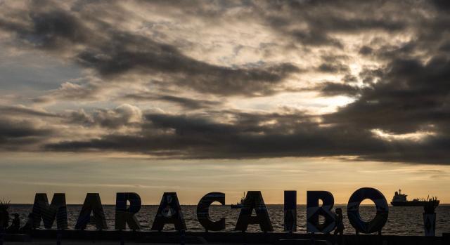 This view shows a sign reading ‘Maracaibo’ with a crude oil tanker anchored on Lake Maracaibo in the background on January 7, 2026. US Energy Secretary Chris Wright said in January 7, Washington will control sales of Venezuelan oil "indefinitely," a day after President Donald Trump announced Venezuela's interim leaders had agreed to US-managed marketing of 30-50 million barrels of crude. (Photo by Maryorin Mendez / AFP)