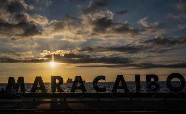 This view shows a sign reading ‘Maracaibo’ with a crude oil tanker anchored on Lake Maracaibo in the background on January 7, 2026. US Energy Secretary Chris Wright said in January 7, Washington will control sales of Venezuelan oil "indefinitely," a day after President Donald Trump announced Venezuela's interim leaders had agreed to US-managed marketing of 30-50 million barrels of crude. (Photo by Maryorin Mendez / AFP)