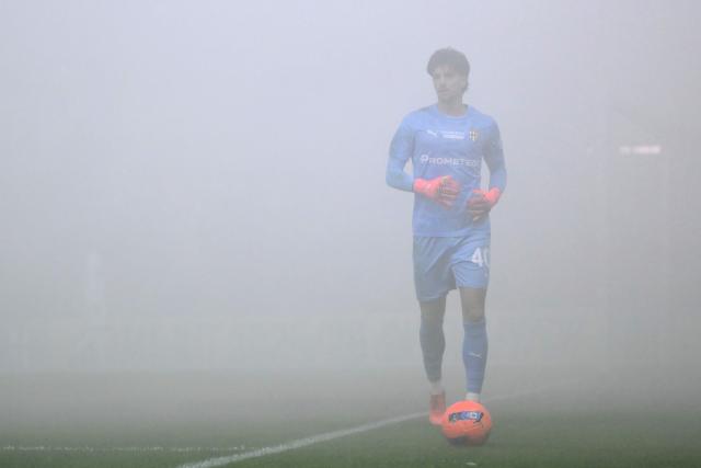 Parma's Italian goalkeeper #40 Edoardo Corvi walks in the mist and the smoke at the start of the Italian Serie A football match between Parma and Inter Milan at the Ennio Tardini stadium in Parma on January 7, 2026. (Photo by Marco BERTORELLO / AFP)