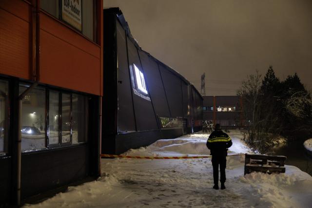 A police officer stands outside a sports centre after it collapsed on Zonnebaan in Utrecht on January 7, 2026. Emergency services are investigating whether anyone the centre. (Photo by Robin van Lonkhuijsen / ANP / AFP) / Netherlands OUT