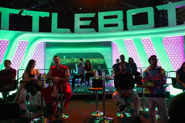 Fighting robot pilot “Master Ken” watches his competition as spectators watch robots fight during the Ultimate Fighting Bots (UFB) competition at the BattleBots Arena on the sidelines of the annual Consumer Electronics Show (CES) in Las Vegas, Nevada on January 6, 2026. (Photo by Patrick T. Fallon / AFP)