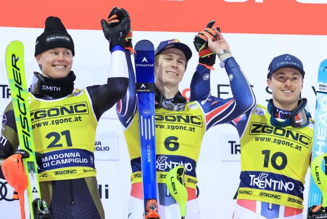 First placed France's Clement Noel (C) celebrates on the podium with second placed Finland's Eduard Hallberg (L) and third placed France's Paco Rassat  after the Men's Slalom event, part of the FIS Alpine Ski World Cup 2025-2026, in Madonna di Campiglio, northern Italy, on January 7, 2026. (Photo by Pierre TEYSSOT / AFP)
