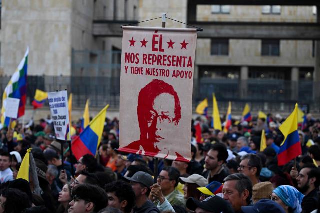 A sign depicting Colombian President Gustavo Petro that reads in spanish "He represents us and has our support," is seen during the March for Sovereignty and Democracy against US President Donald Trump's threats to Colombia's President Gustavo Petro at Bolivar Square in Bogota on January 7, 2026. On January 5, Colombian President Gustavo Petro said he was ready to "take up arms" in the face of threats from US counterpart Donald Trump, who over the weekend seized the leader of neighboring Venezuela in a military strike. (Photo by LUIS ACOSTA / AFP)
