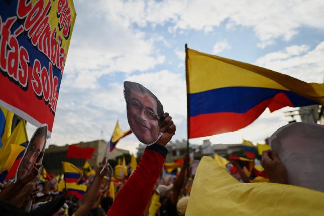 A demonstrator shows an image depicting Colombian President Gustavo Petro during the March for Sovereignty and Democracy against US President Donald Trump's threats to Colombia's president in Cali, Colombia, on January 7, 2026. On January 5, Colombian President Gustavo Petro said he was ready to "take up arms" in the face of threats from US counterpart Donald Trump, who over the weekend seized the leader of neighboring Venezuela in a military strike. (Photo by Joaquin SARMIENTO / AFP)