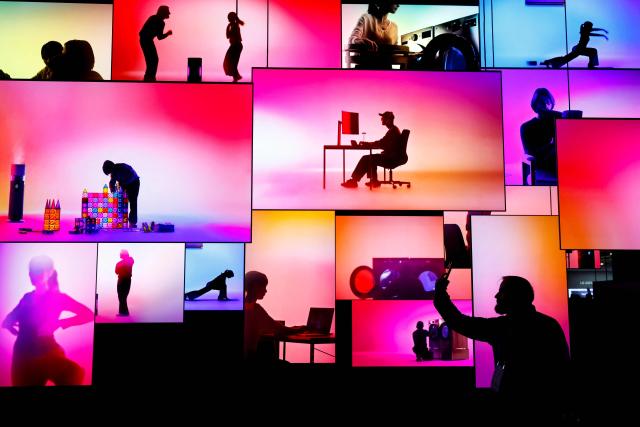 An attendee stands in front of LG 's In Tune monument, a large scale installation composed of 38 LG OLED evo W6 Wallpaper TVs at the annual Consumer Electronics Show (CES) in Las Vegas, Nevada, on January 6, 2026. (Photo by Caroline Brehman / AFP)