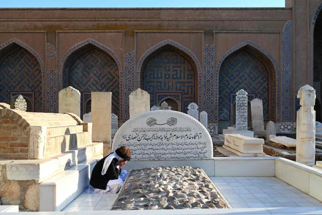 An Afghan boy offers prayers over a grave at the Khwaja Abdullah Ansari Shrine in Gazargah area of Herat on January 7, 2026. (Photo by Wakil KOHSAR / AFP)