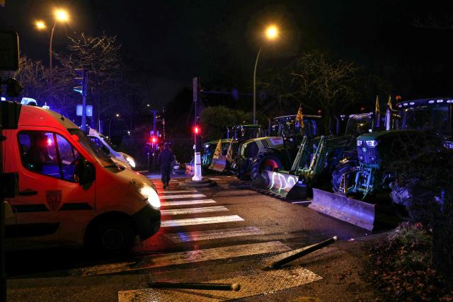 Police vehicles face tractors blocking a road during a demonstration of French agricultural union Coordination Rurale (CR) as part of a nationwide day of protests and actions called by several farmers unions to push the French government to block the Mercosur trade deal and protest against its handling of the nodular dermatitis (CND) epidemic, near the Porte d'Auteuil metro station in Paris on January 8, 2026. (Photo by Thomas SAMSON / AFP)