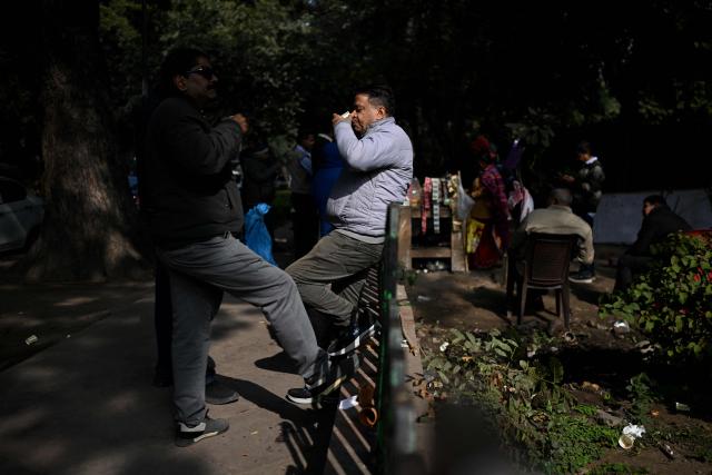 People drink tea at a roadside stall in New Delhi on January 8, 2026. (Photo by Sajjad HUSSAIN / AFP)