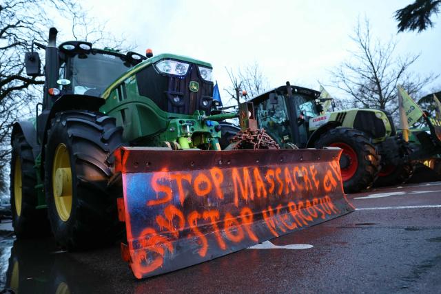 Farmers block a road with tractors at Porte d'Auteuil during a demonstration of French farmers union FDSEA as part of a nationwide day of protests and actions called by several farmers unions to push French government to block the Mercosur trade deal and protest against its handling of the nodular dermatitis (CND) epidemic, in Paris on January 8, 2026. (Photo by Thomas SAMSON / AFP)